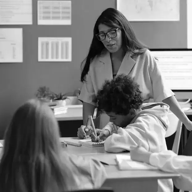 Teacher guiding students in a classroom with FASST CABAS methodology.